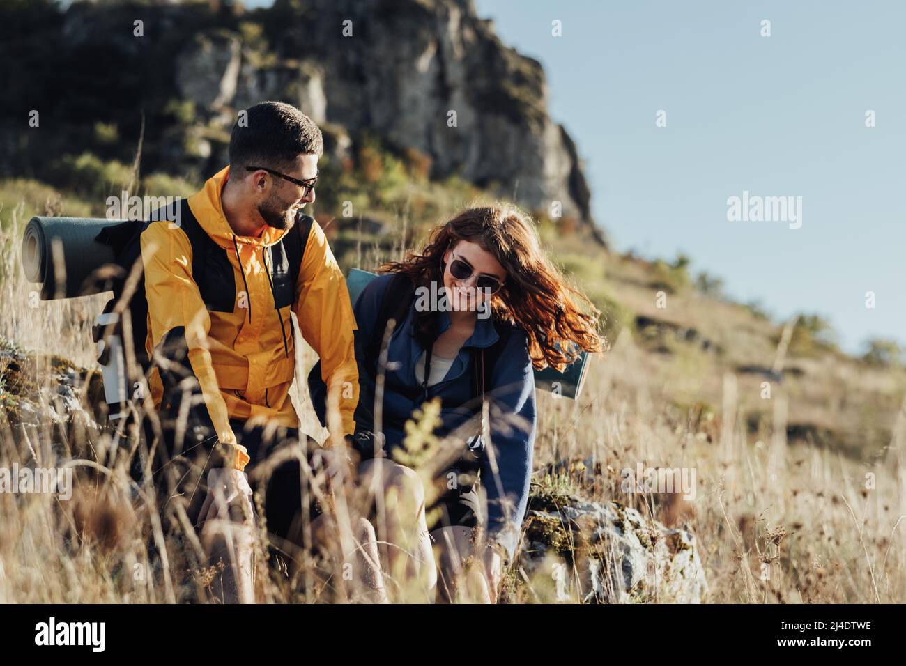 Zwei junge Reisende Mann und Frau machten während ihrer Wanderung auf dem Gipfel des Hügels einen Halt, um sich auszuruhen Stockfoto