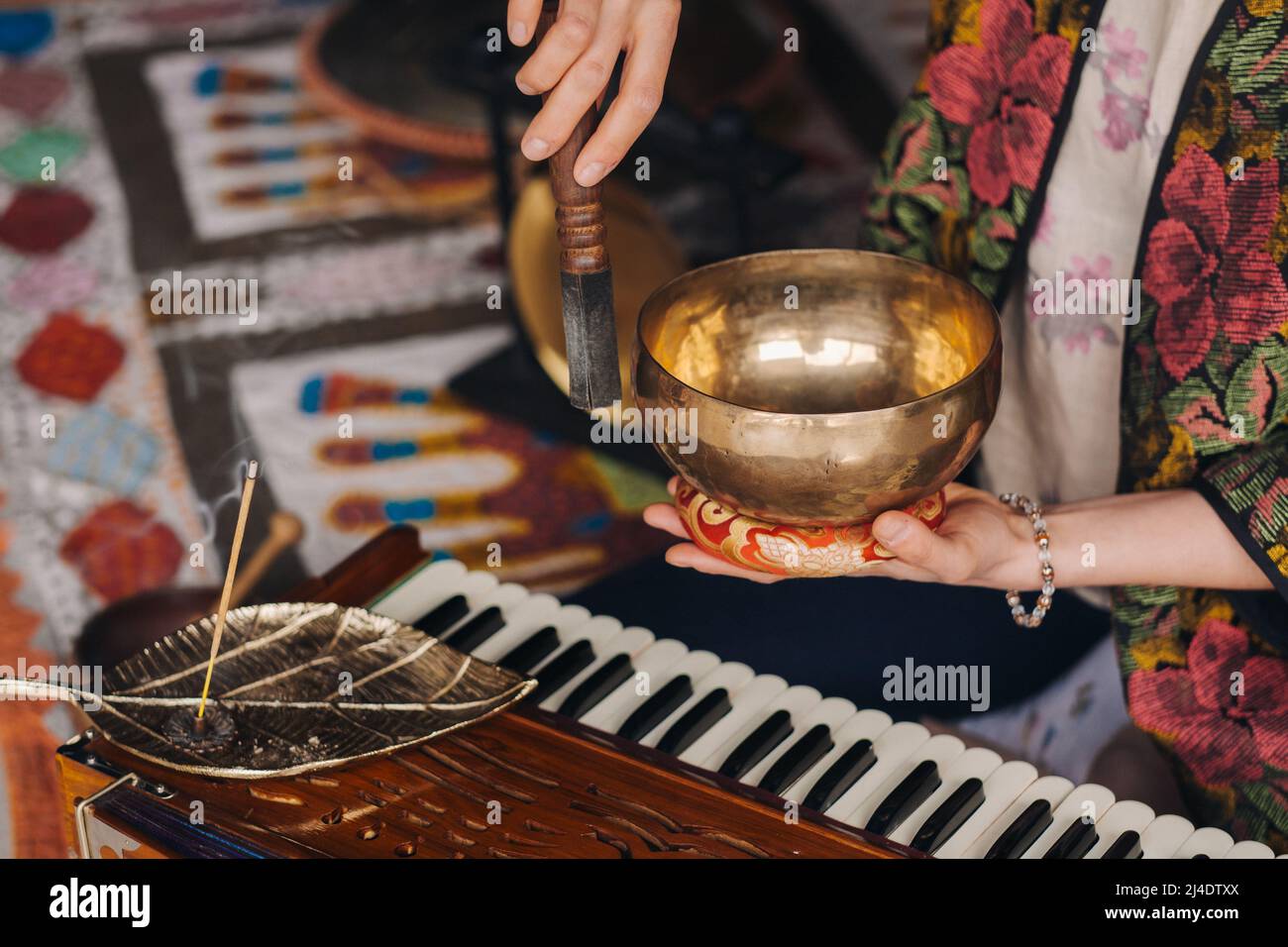 Tibetische Klangschale in den Händen eines Mannes während einer Teezeremonie Stockfoto