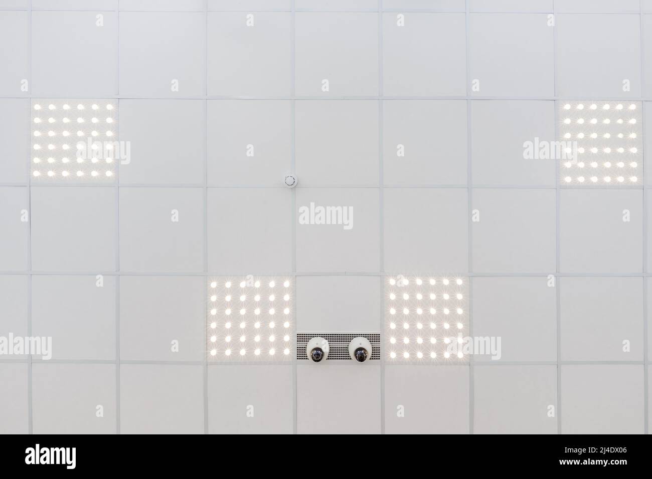 Abgehängte Decke mit Halogenstrahlern und Trockenmauerkonstruktion im leeren Raum in Wohnung oder Haus. Stretchdecke weiß und komplex. Stockfoto