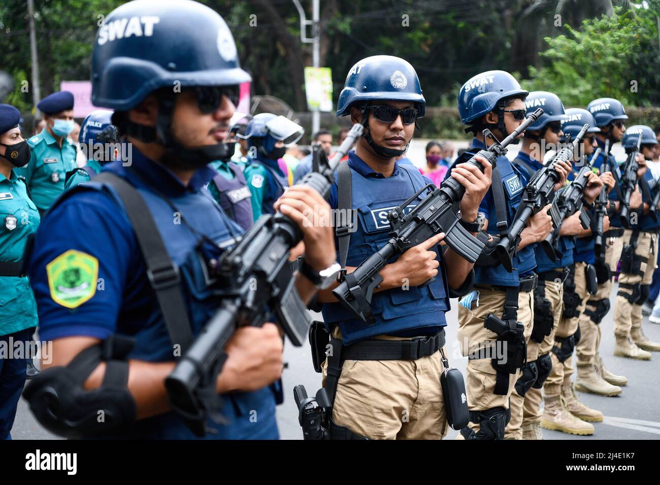 Mitglieder der Spezialsicherheitseinheit "SWAT (Spezialwaffen und Taktik)" werden während der Feier des ersten Tages des bengalischen Neujahrs eingesetzt. Menschen aus Bangladesch nehmen an einer bunten Parade Teil, um den ersten Tag des bengalischen Neujahrs oder Pohela Boishakh am 14. April zu feiern. Tausende von Menschen aus Bangladesch feiern es mit verschiedenen bunten Kundgebungen, kulturellen Programmen mit traditionellem Tanz und Musik, dieses bengalische Jahr wurde während des Regimes von Kaiser Akbar eingeführt, um die Einnahmeerhebung im 16.. Jahrhundert zu erleichtern. Stockfoto