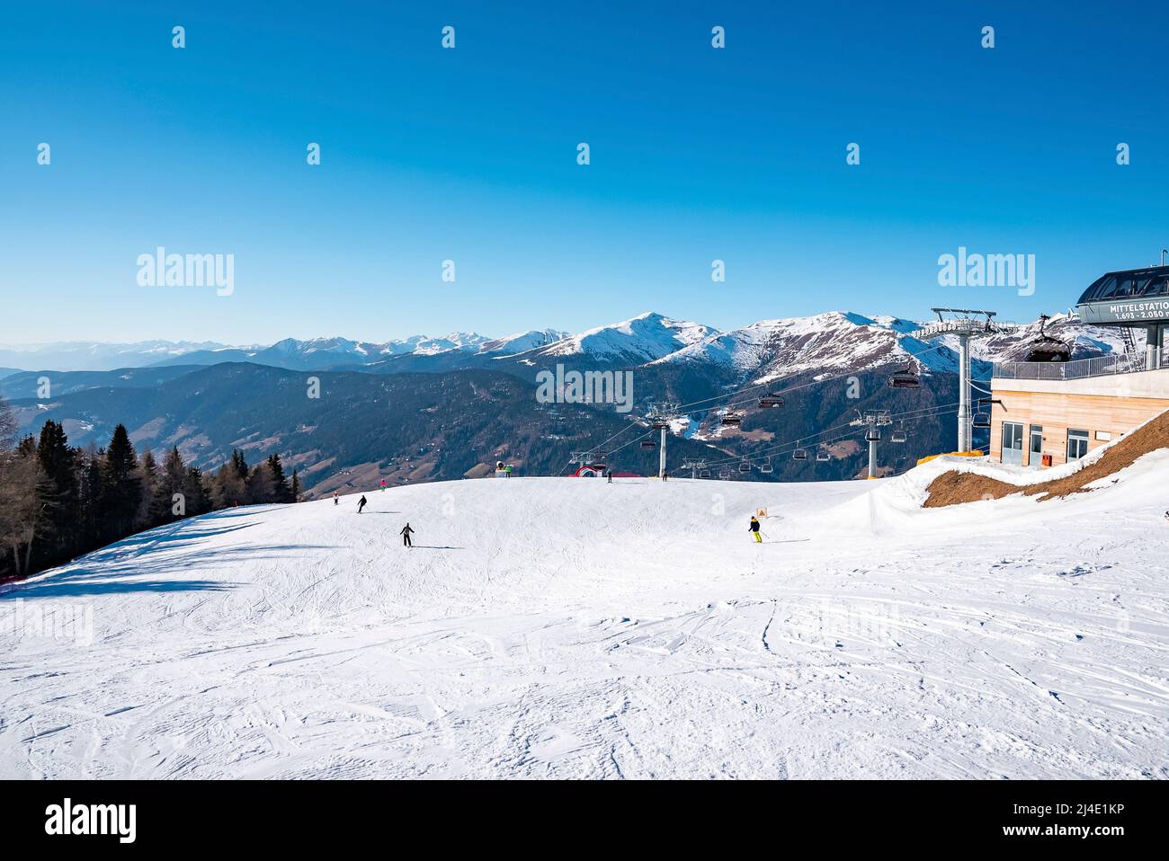 Blick auf die Pisten an der Skistation und schneebedeckte majestätische Berge gegen den Himmel Stockfoto
