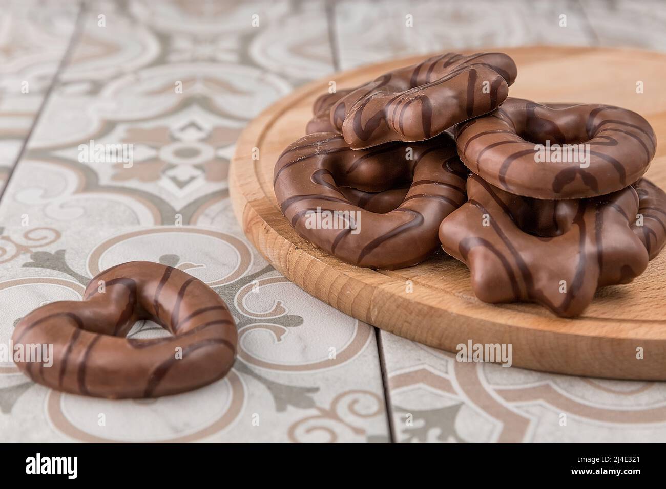 Kekse zum Valentinstag. Mit Schokolade beschichtete Lebkuchenkekse. Sie liegen auf einem Schneidebrett auf dem Tisch. Stockfoto