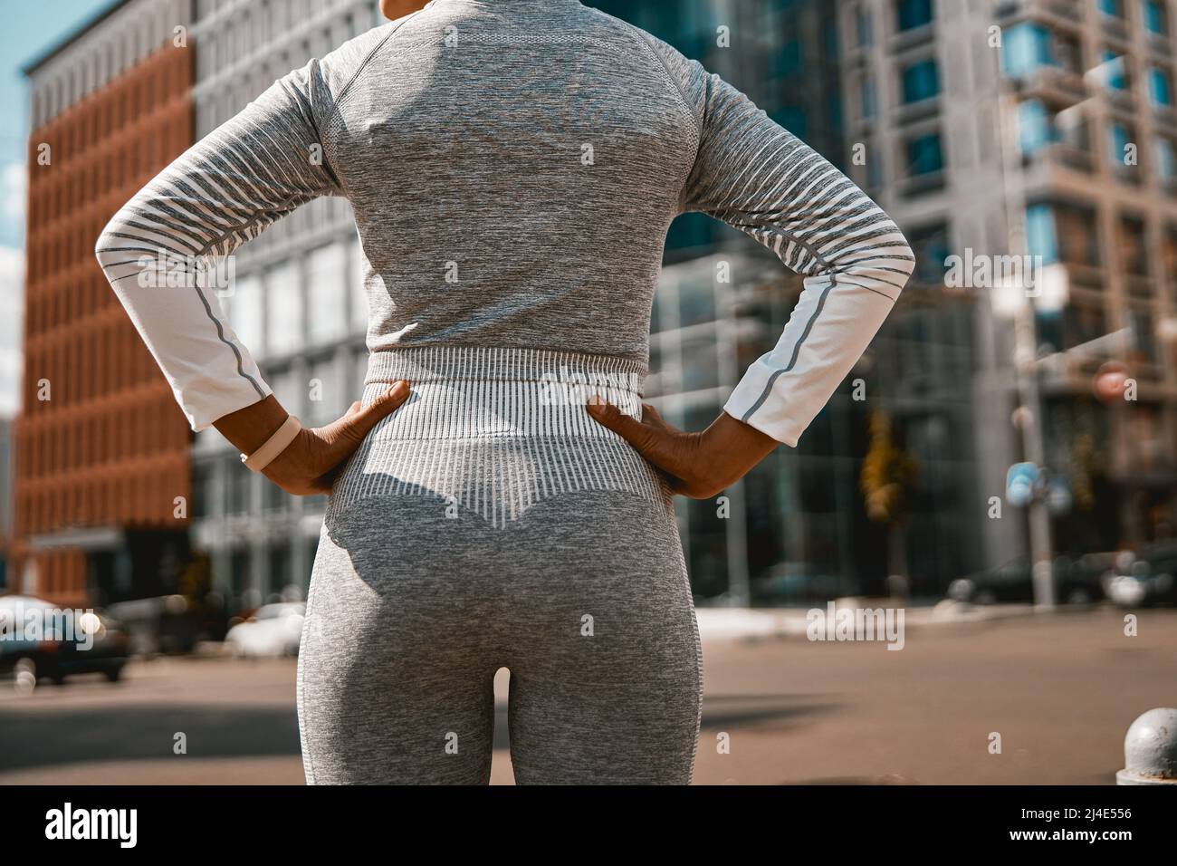 Rückansicht einer Sportlerin in aktiver Kleidung, die auf der Straße steht Stockfoto