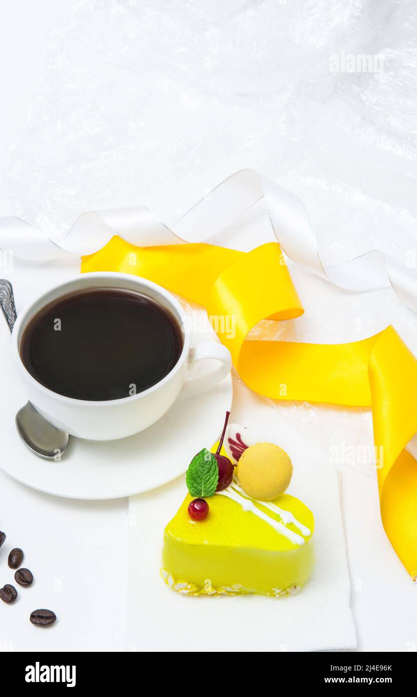 Tasse mit Kaffee und Zitronenkuchen in Form eines Herzens Stockfoto