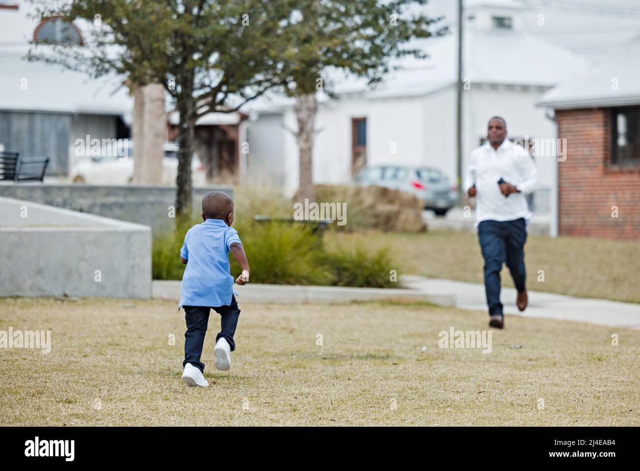 Ein Sohn im Vorschulalter läuft zu seinem Vater, um abgeholt zu werden Stockfoto
