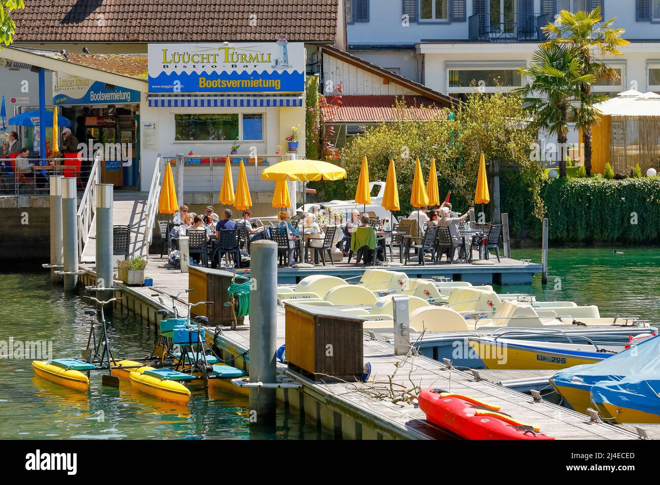 Weggis, Schweiz - 05. Mai 2016: Speisen und Getränke werden von nicht identifizierten Gästen der Bistro-Bar genossen. Die Gäste sitzen an Tischen, die auf dem pi aufgestellt sind Stockfoto