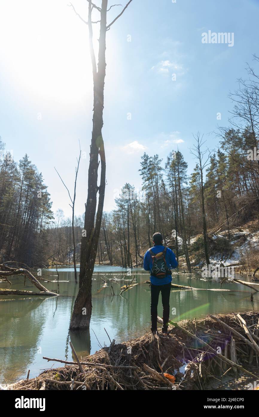 Fotograf mit Rucksack auf den Schultern und mit DSLR-Kamera in seinem und geht entlang der Biber-Mutter und Suche nach einem Bild Stockfoto