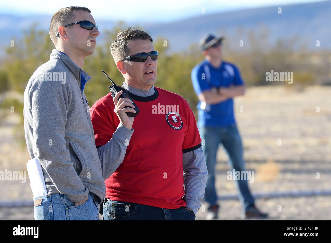 Casey Kleisinger, ein Mitglied des Teams von Robins Air Force Base, Ga. und Kapitän John Walton, 2016 Air Force Research Laboratory Commanders Challenge Program Execution Officer, hören Radio Kommunikation während der Veranstaltung an der Nevada National Security Website, Las Vegas, NV., Dez. 13, 2016. Mannschaften wurden sechs Monaten eine komplette Zähler - Unmanned Aerial Systems in Base Defense zu Hilfe zu entwickeln. Robins' system ist eine vielschichtige integriertes System verwendet ein Radar und Kamera System für den Nachweis und die Identifizierung. Es verwendet auch ein Hunter killer Drohnen für die Überwachung des Fernmeldeverkehrs und Wasserwerfer für Sh Stockfoto