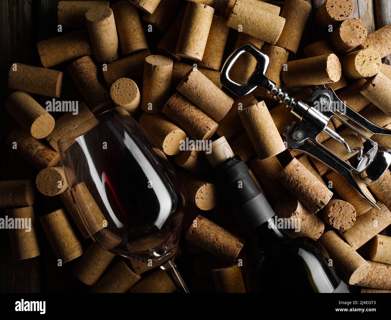 Festliche Komposition. Eine Flasche Rotwein, ein Weinglas und ein Korkenzieher auf dem Hintergrund von Weinkorken. Viele Objekte. Weinprobe, som Stockfoto
