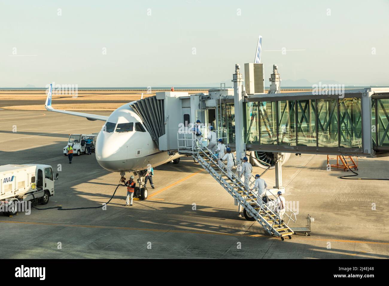 Reinigungs- und Wartungspersonal, das am Terminal am Flughafen Yamaguchi Ube, Japan, an Bord eines ANA-Flugzeugs geht Stockfoto