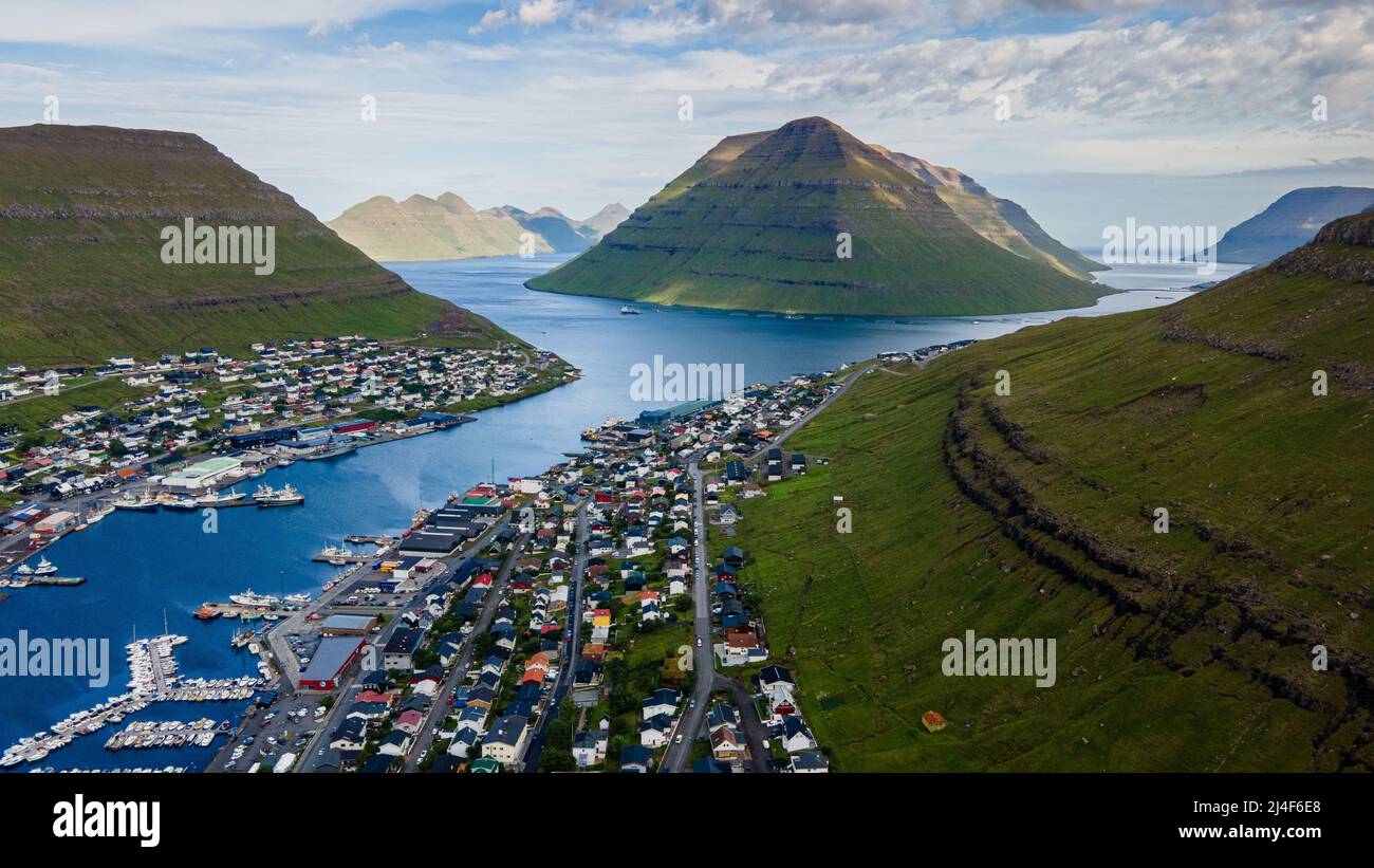 Wunderschöner Blick aus der Vogelperspektive auf die Stadt Klaksvik auf den Fareo-Inseln mit ihren bunten Häusern und dem atemberaubenden Kanal und Blick auf den majestätischen Kunoy Park Stockfoto