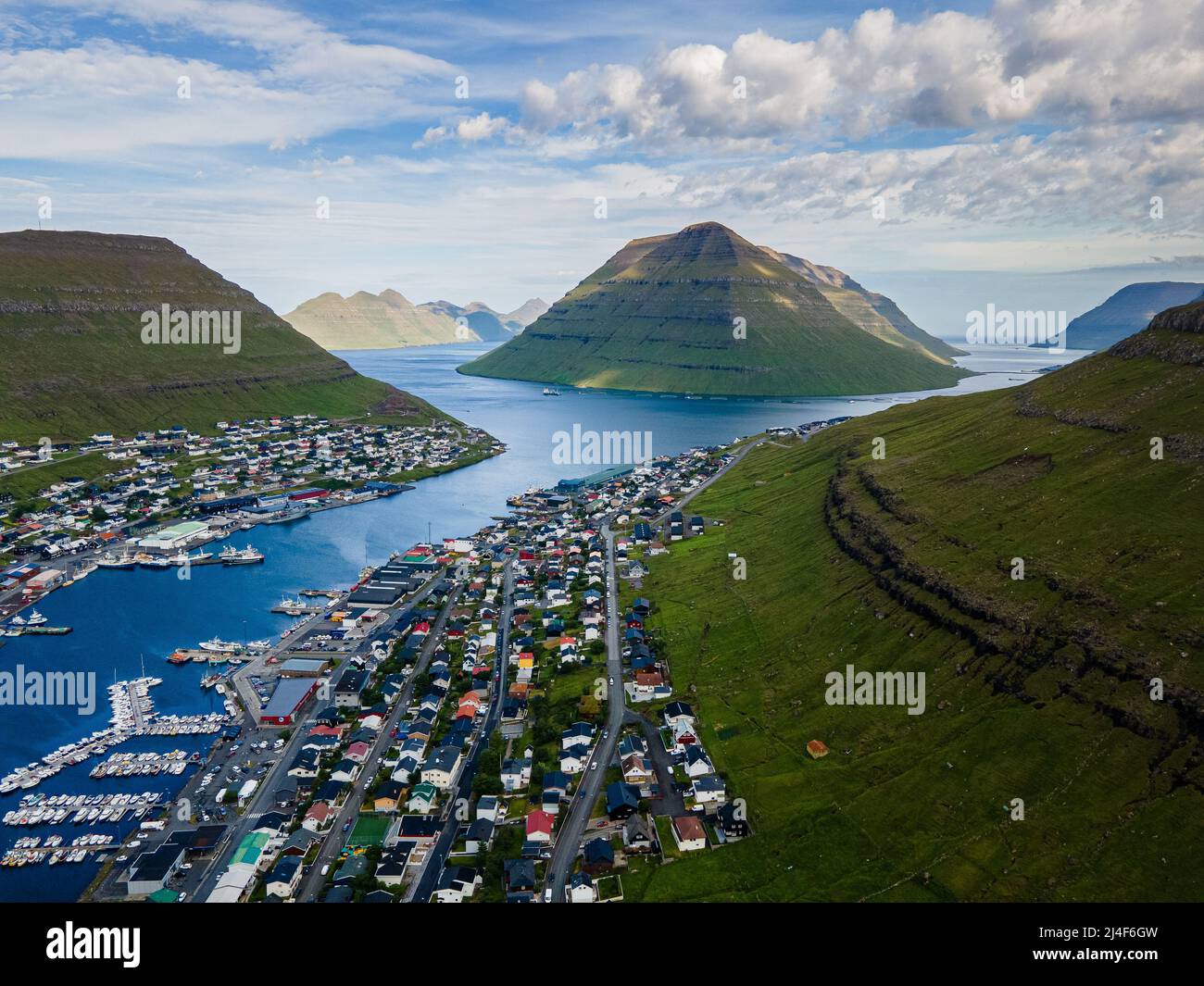 Wunderschöner Blick aus der Vogelperspektive auf die Stadt Klaksvik auf den Fareo-Inseln mit ihren bunten Häusern und dem atemberaubenden Kanal und Blick auf den majestätischen Kunoy Park Stockfoto