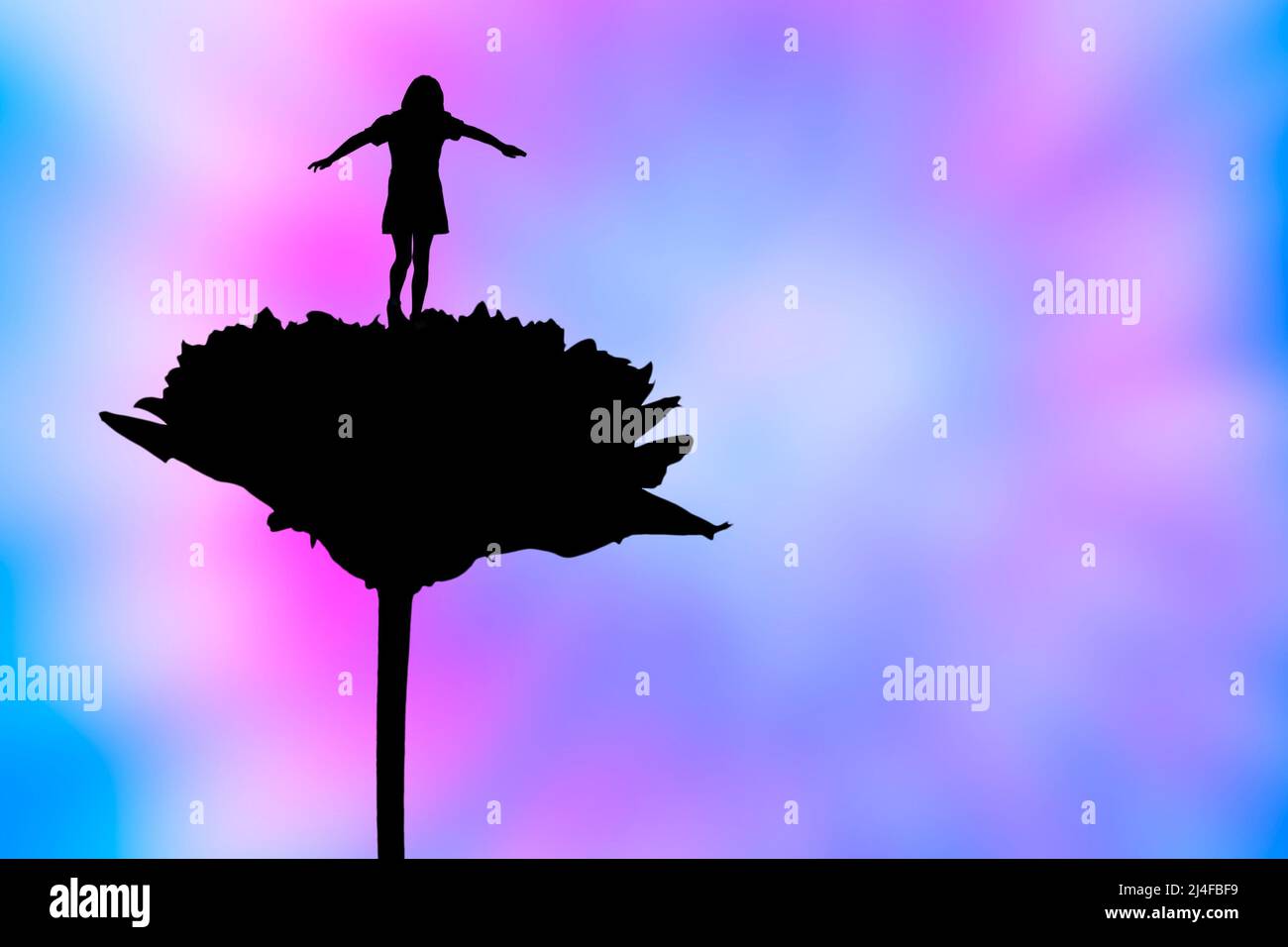 Mädchen balanciert auf einer riesigen Blume Stockfoto