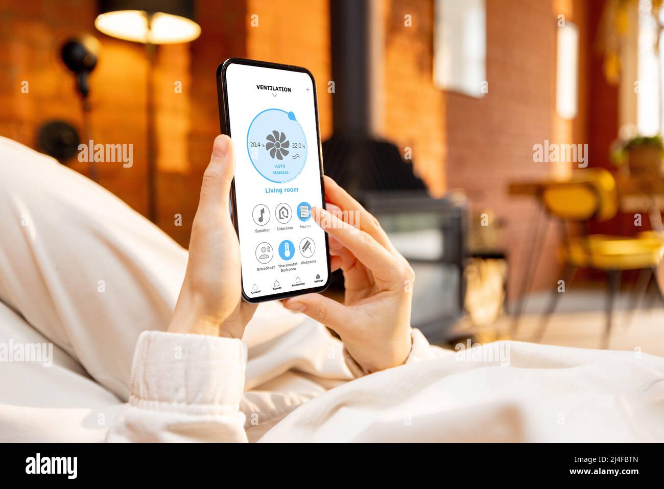 Frau mit Smartphone und Smart-Home-Anwendung Stockfoto