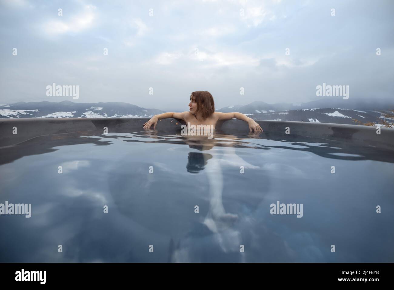 Frau, die im Whirlpool in den Bergen badete Stockfoto