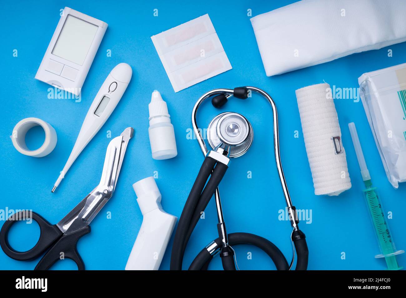 Erste Hilfe Kit mit medizinischen Geräten auf blauem Hintergrund Stockfoto