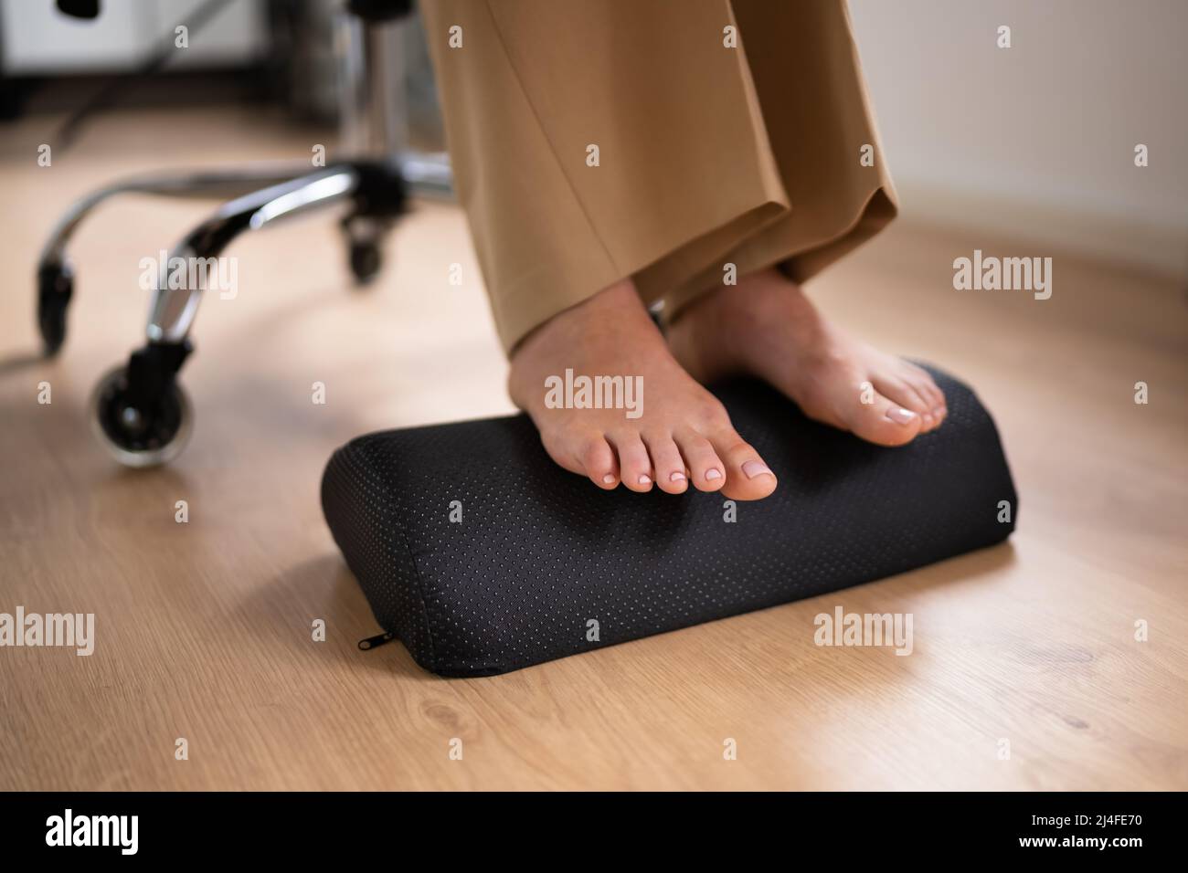 Arbeiter, Die Fußstütze Verwenden, Um Rückenbelastung Und Ermüdung Der Füße Zu Reduzieren Stockfoto