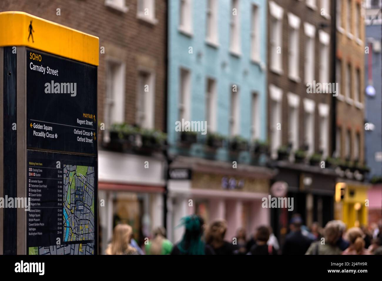 LONDON, Großbritannien - 13. APRIL 2022: Touristeninformationsschild in der Carnaby Street mit defokusserem Hintergrund Stockfoto