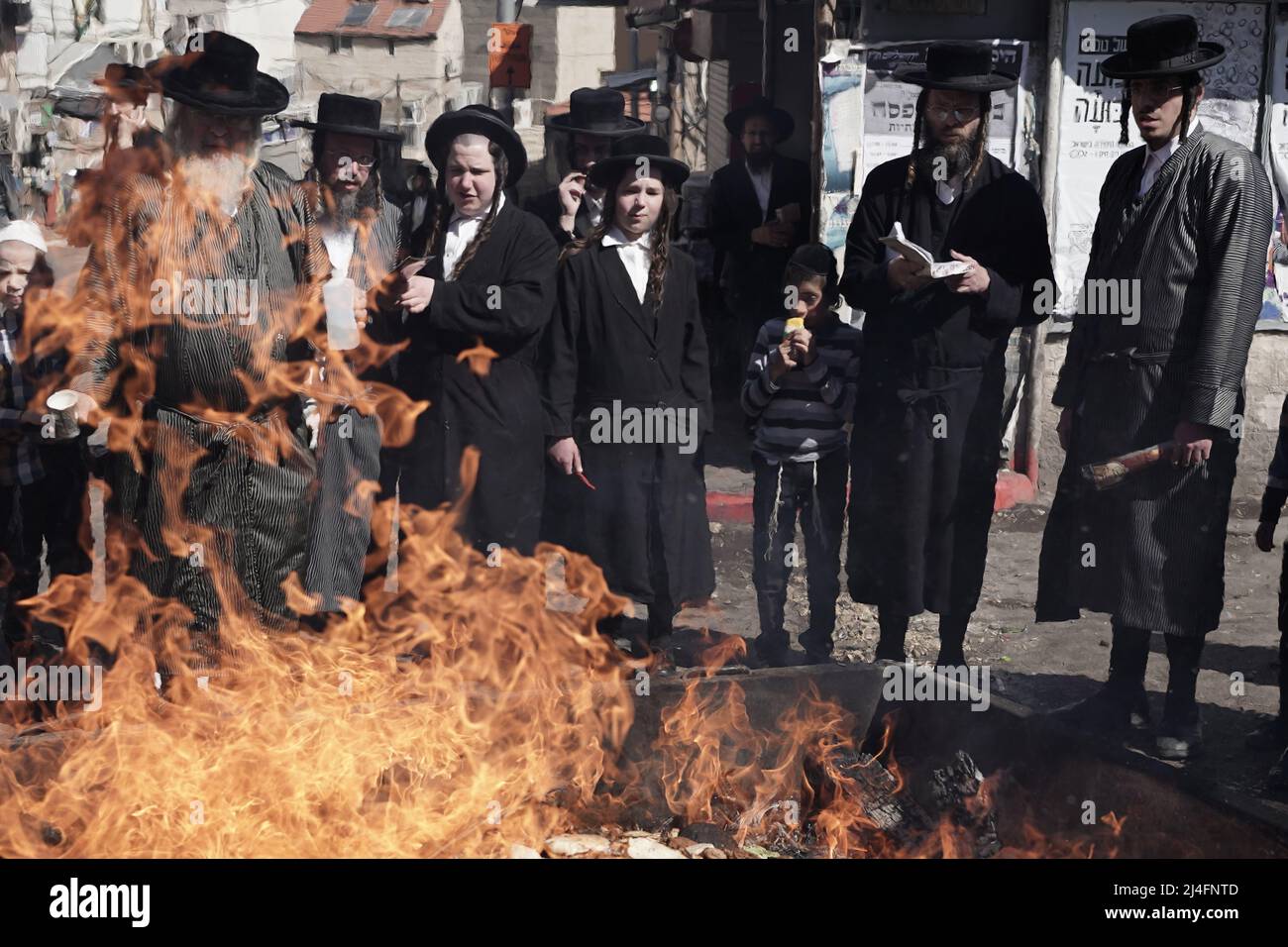 Jerusalem, Israel. 15. April 2022. Ultra-orthodoxe Juden verbrennen Brotfetzen, ungesäuerte Waren und Gegenstände aus Hefe im zeremoniellen biur chametz, das Verbrennen von ungesäuertem Brot, das das Land während des Passahfestes reinigen soll, das heute Nachmittag in der Abenddämmerung beginnt. Kredit: Nir Alon/Alamy Live Nachrichten Stockfoto