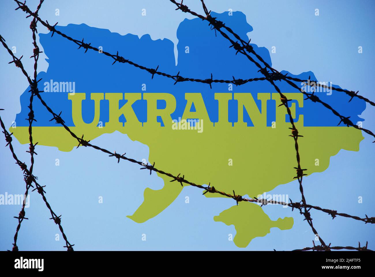 Krieg in der Ukraine, Stacheldraht, ukrainische Flagge, Angriff auf die Ukraine durch Russen. Bedrohung für Europa Stockfoto