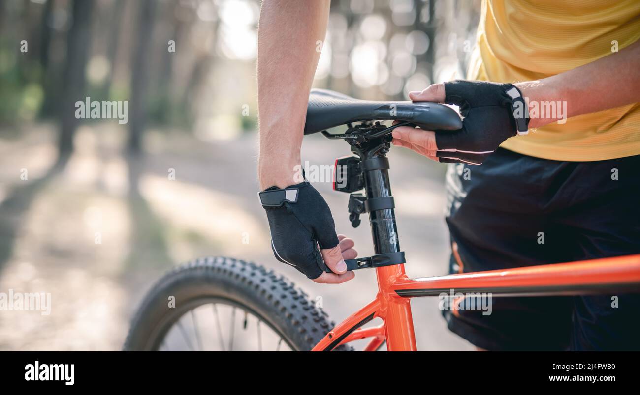 Fahrer passt die Sitzhöhe am Fahrrad an Stockfoto