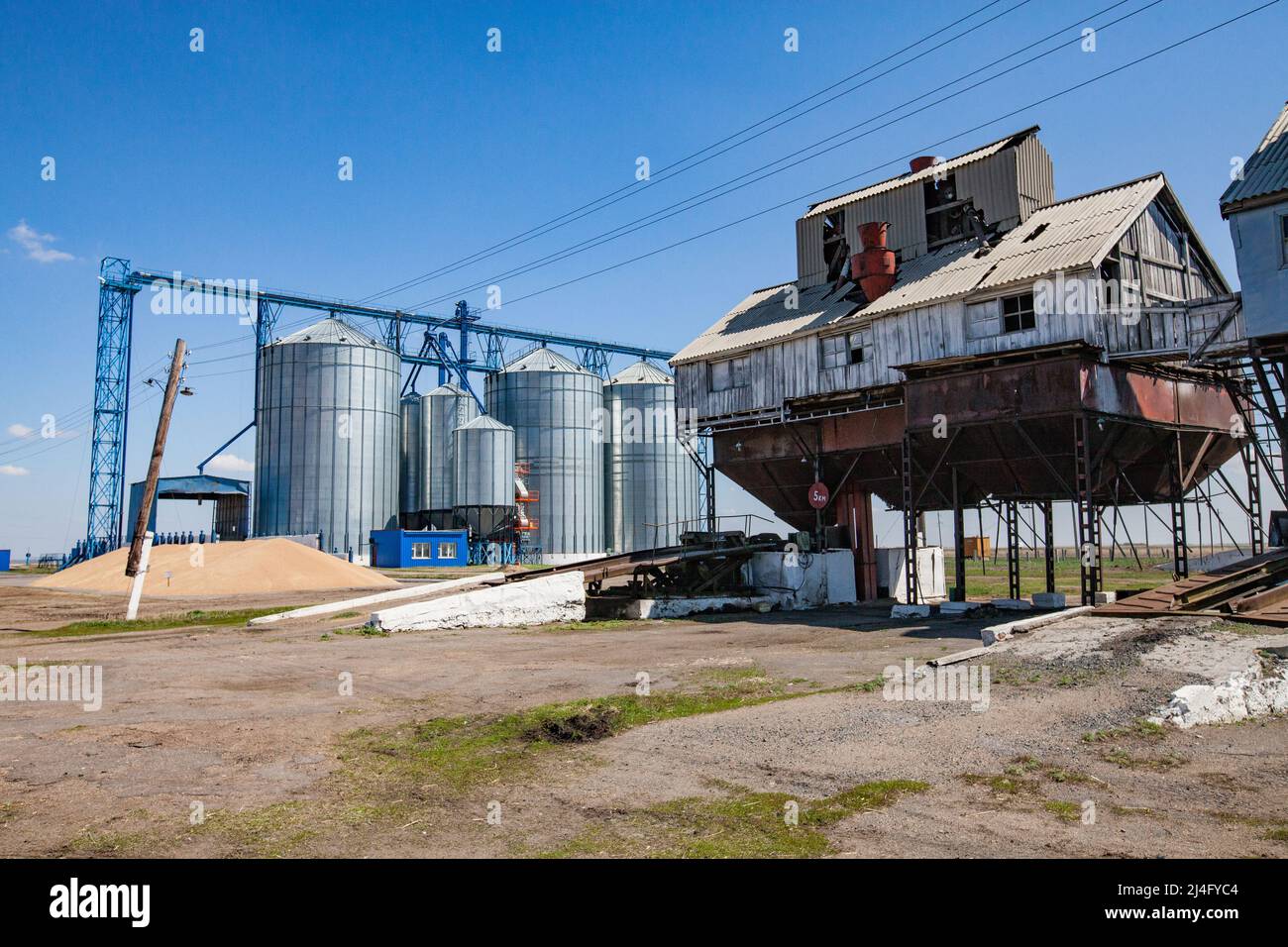 Provinz Nordkasachstan, Kasachstan - 12. Mai 2012: Alte sowjetische Getreidelagerung (rechts) und moderne Stahlaufzugssilos (links) Stockfoto