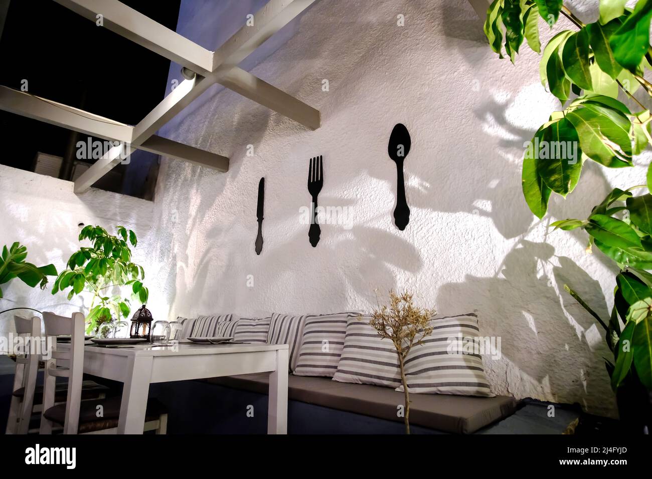 IOS, Griechenland - 13. Juni 2021 : Blick auf einen wunderschön dekorierten Tisch auf einer Außenterrasse bei Nacht in iOS Griechenland Stockfoto