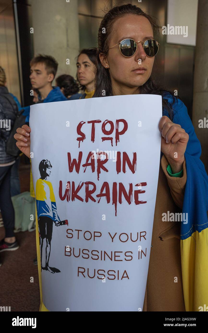 Eine Protesterin hält während der Demonstration ein Plakat, auf dem sie ihre Meinung außerhalb des Außenministeriums zum Ausdruck bringt. Tag 50 der russischen Invasion der ukrainischen und Präsidenten Alexander Lukaschenko drängende Frage, wie er mit den europäischen Staats-und Regierungschefs heute Morgen kommuniziert: Die Länder weiterhin für russisches Öl bezahlen, aus dem Russland Milliarden pro Woche macht. Die Käufer verdienten „ihr Geld aus dem Blut anderer Menschen“, sagte er. Mehr als vierzig Demonstranten, darunter Kinder und ukrainische Flüchtlinge, versammelten sich heute Nachmittag vor den Außenministerien und trugen die nationalen gelben und Stockfoto