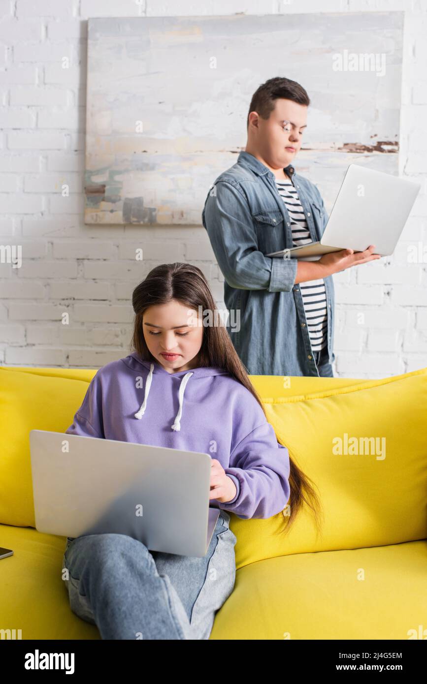 Teen Mädchen mit Down-Syndrom mit Laptop in der Nähe von Freund zu Hause Stockfoto