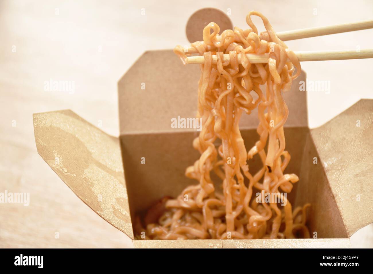 Gebratene japanische Yakisoba-Nudeln schneiden Schweinespeck und Kohl in einer Schachtel, die mit Essstäbchen pflücken Stockfoto