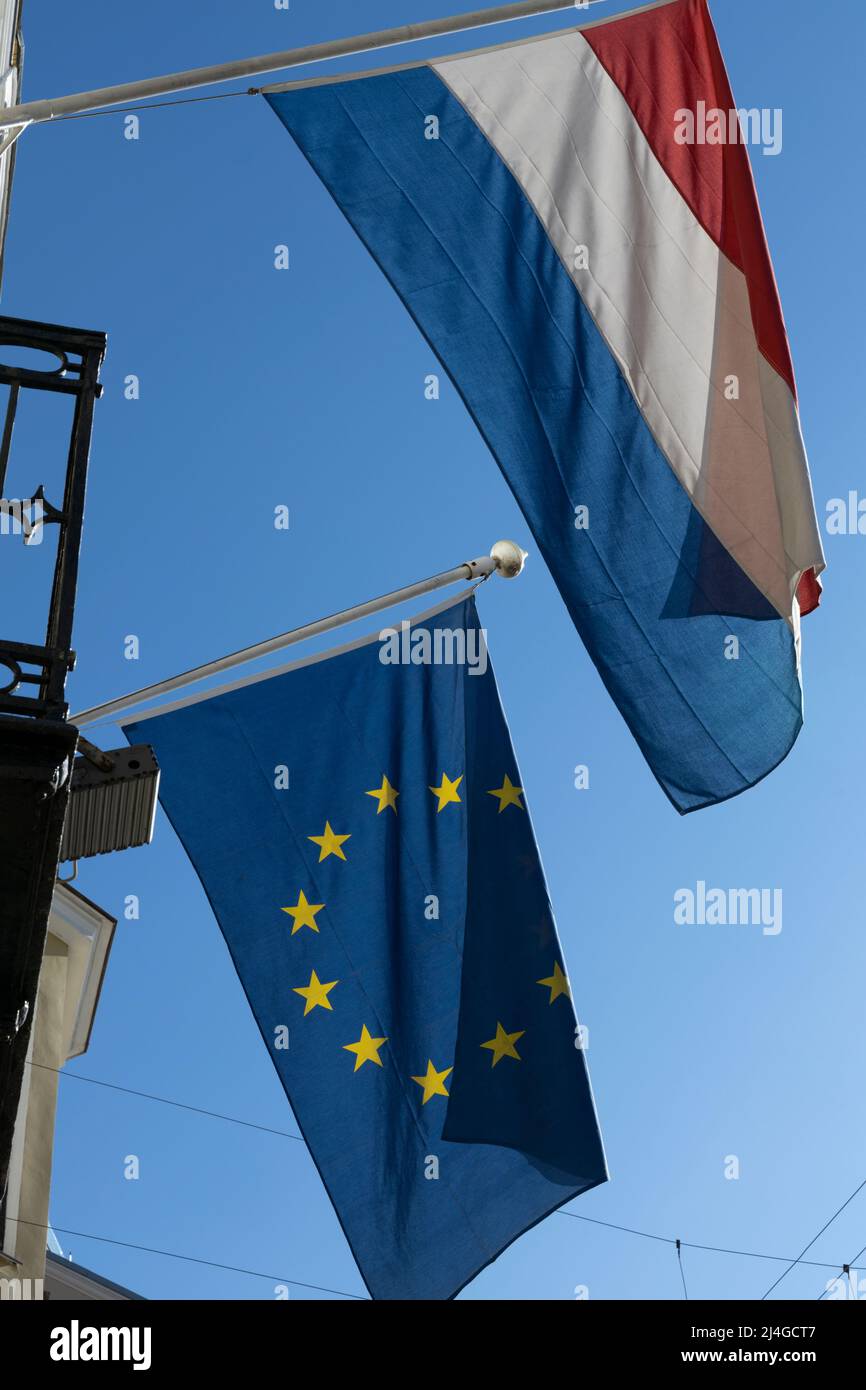 Flaggen der Niederlande und der Europäischen Union flattern im Wind, die an den Flagstaffs befestigt sind Stockfoto