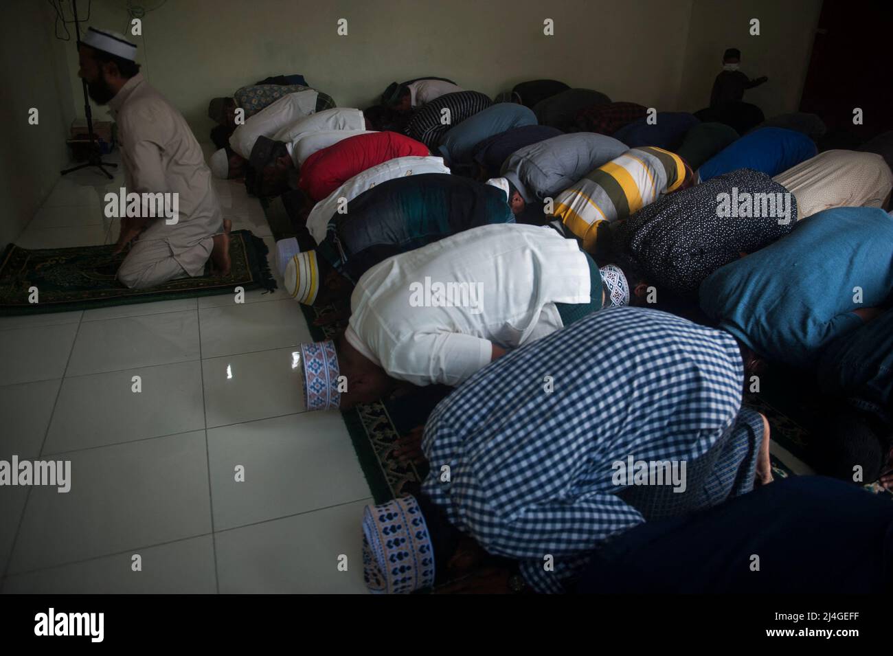 Muslimische Asylsuchende werden gesehen, wie sie während des heiligen Ramadan in einem vorübergehenden Flüchtlingsheim in Medan, Provinz Nord-Sumatra, Indonesien am 15. April 2022 zusammen beten, während der Teil der Internatsausbildung blinkt. Mit dieser einwöchigen Ausbildung hofft die Internationale Organisation für Migration durch die Geutanyoe-Nichtregierungsorganisation, bis zu 60 Teilnehmer des Flash-Internats, nämlich Generationen von Asylbewerbern aus Myanmar, Afghanistan und Birma in Indonesien, durch eine nichtformale Ausbildung auszustatten, bevor sie Asyl aus anderen Ländern erhalten, Sagte der Coordi Stockfoto