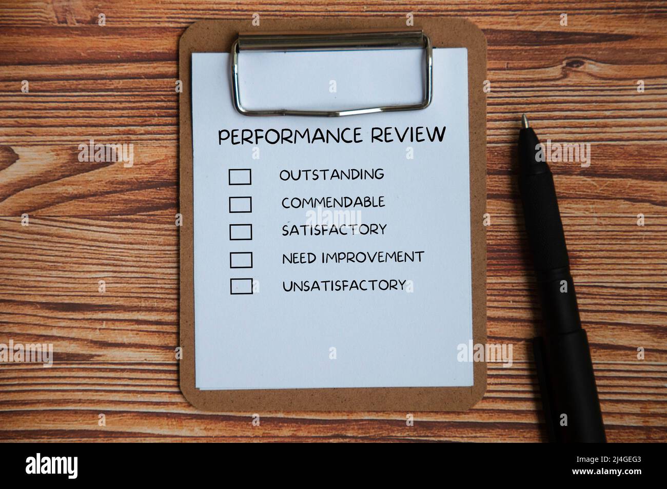 Draufsicht der Leistungsbeurteilung Checkliste auf Clipboard mit Stift und Holzabdeckung Hintergrund. Konzept der Leistungsbeurteilung Stockfoto