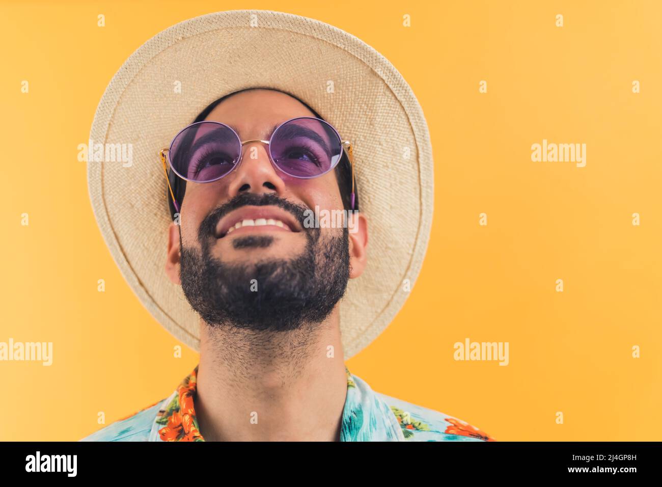 Attraktive junge Latino-Amerikaner mit einem Hut und Sonnenbrille genießen mit Sommer Nahaufnahme orange Hintergrund Studio shot Urlaubskonzept . Hochwertige Fotos Stockfoto