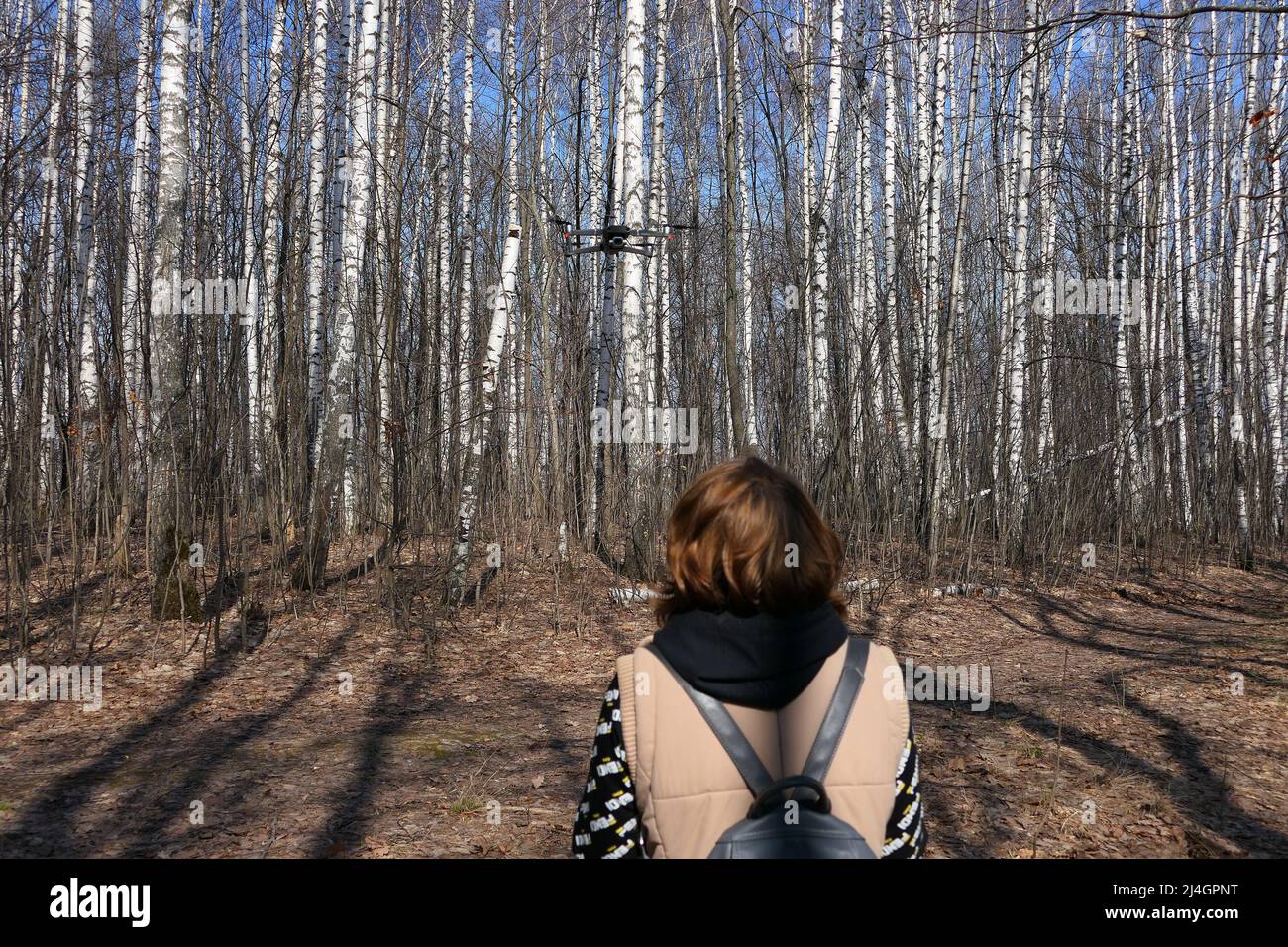 Nischni Nowgorod, Russland, Raspberry Ridge Nature Reserve, 13.04.2022. Mädchen, reist und kontrolliert eine Drohne im Wald im Freien. Hochwertige Fotos Stockfoto