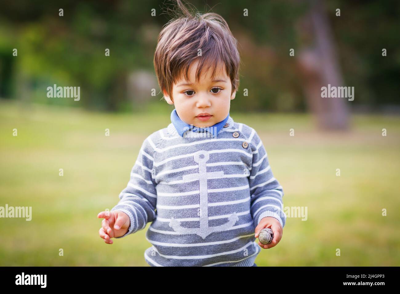 Kleiner, im Osten hübscher Junge, der im Park draußen spielt Stockfoto