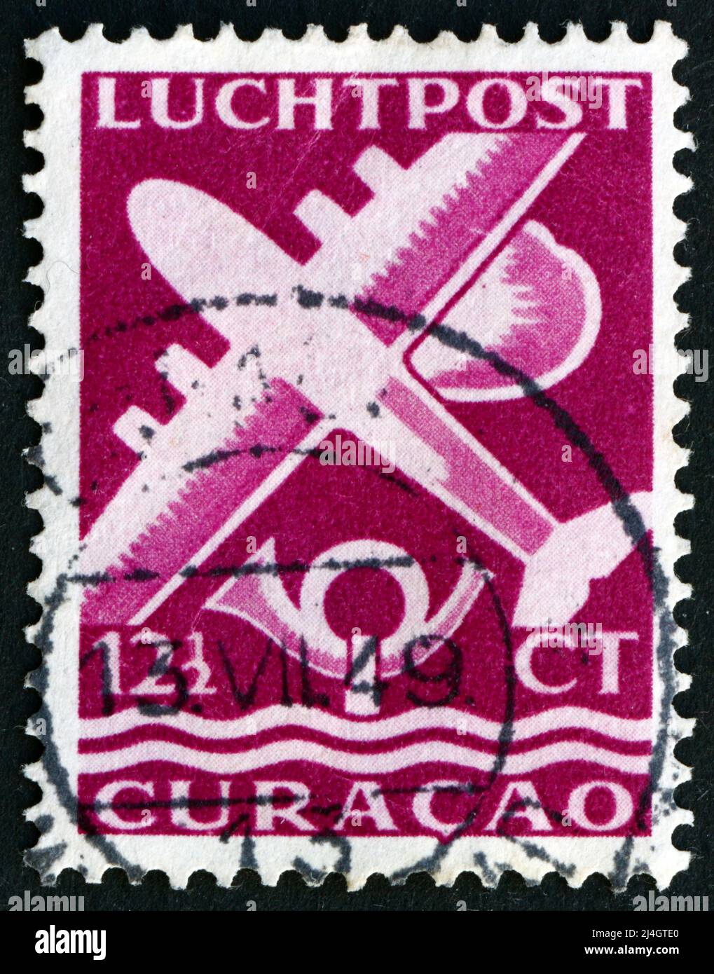 NIEDERLÄNDISCHE ANTILLEN - UM 1947: Eine in Niederländische Antillen, Curacao gedruckte Marke zeigt Flugzeug und Posthorn, um 1947 Stockfoto