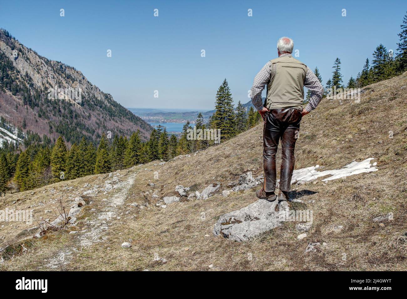 In den bayerischen Alpen steht ein Bergwanderer auf dem 1129 Meter hohen Spitzingsattel und blickt ins Tal hinunter zum Schliersee. Stockfoto