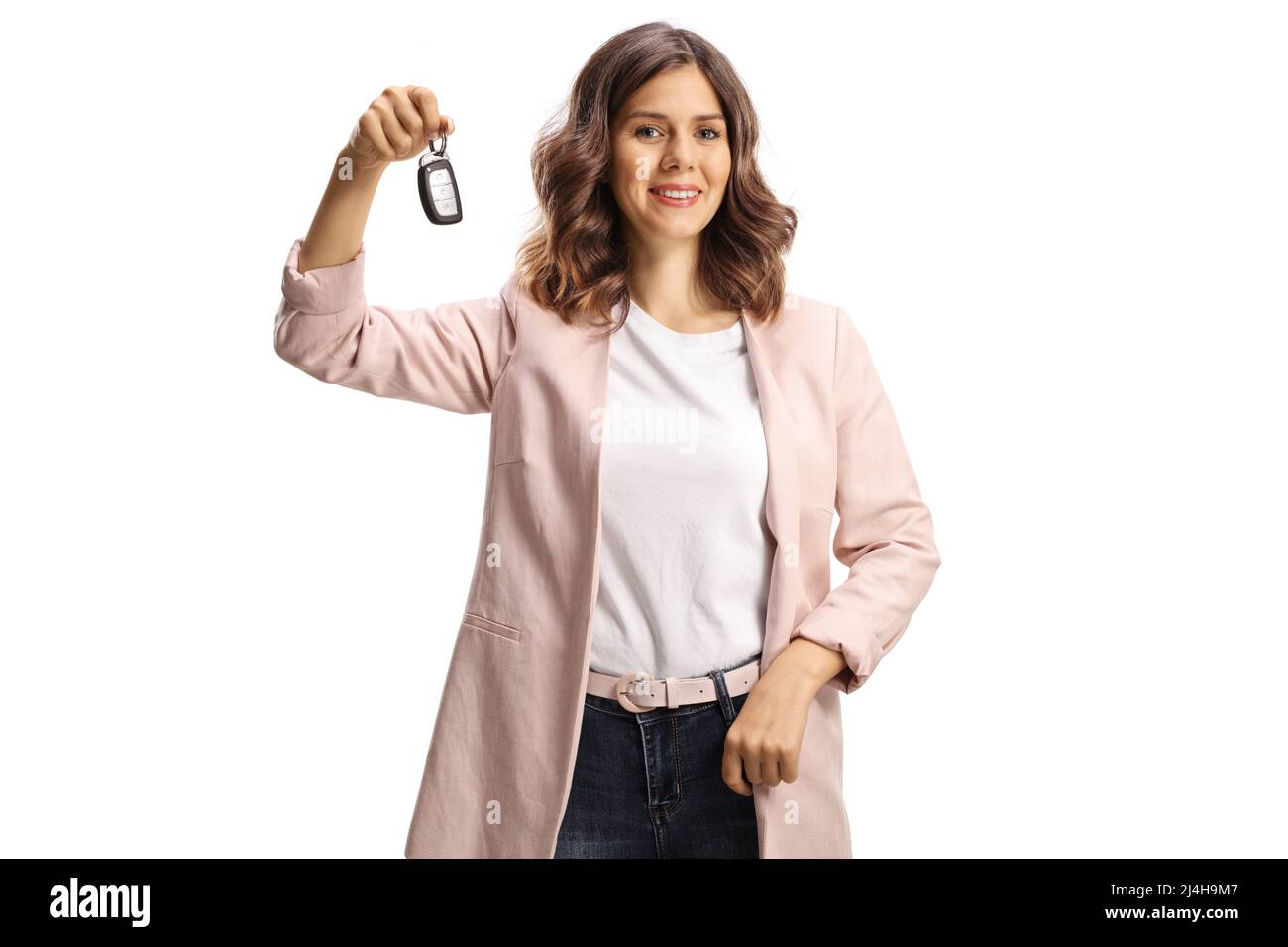 Junge Frau mit Autoschlüssel und lächelnd isoliert auf weißem Hintergrund Stockfoto