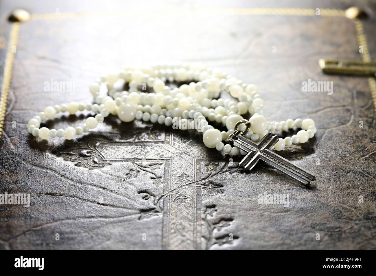 rosenkranz auf dem Cover einer alten bibel Stockfoto