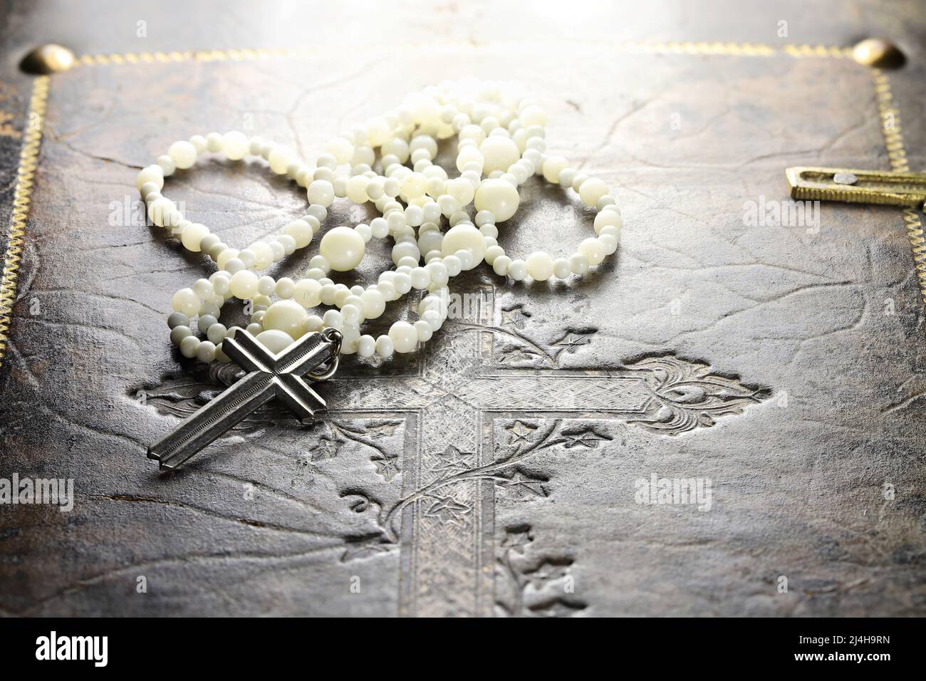 rosenkranz auf dem Cover einer alten bibel Stockfoto