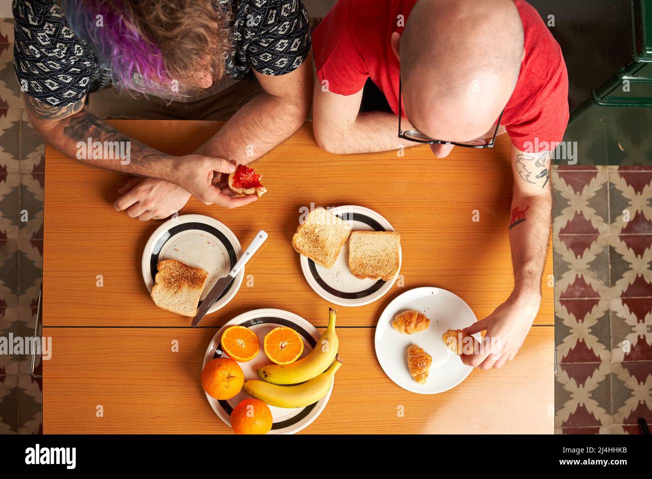 Blick von oben auf einen Tisch in der Küche mit zwei schwulen Männern beim Frühstück Stockfoto