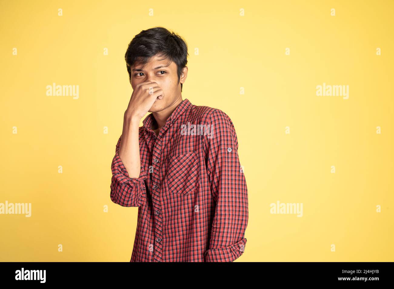 Der Mann bedeckt seine Nase und fühlt sich angewidert vom Geruch Stockfoto