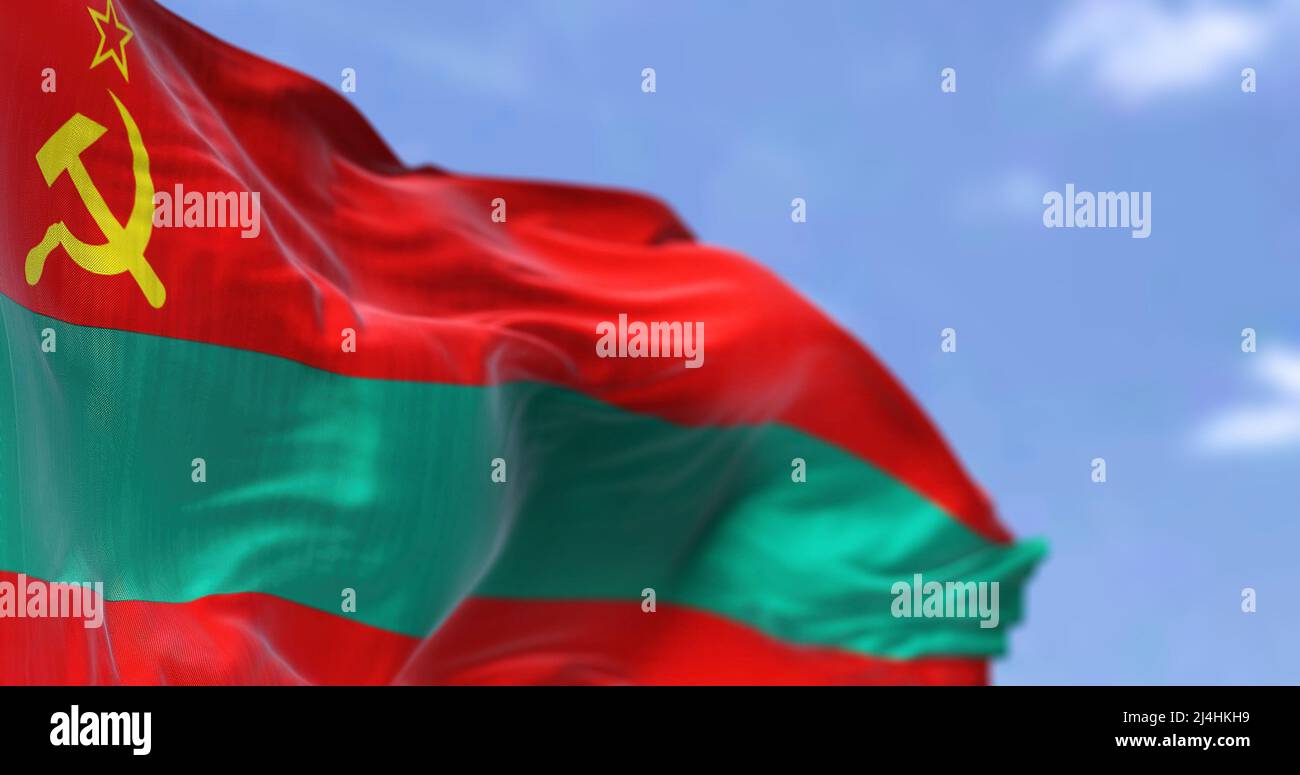 Nahaufnahme der im Wind winkenden transnistrischen Nationalflagge. Im Hintergrund ein klarer Himmel. Patriotismus und Stolz. Selektiver Fokus Stockfoto