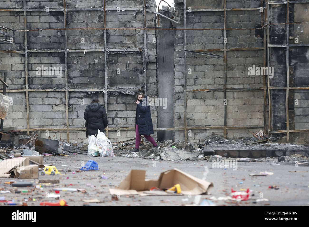 Mariupol. 14. April 2022. Menschen gehen an einem beschädigten Gebäude in Mariupol vorbei, 14. April 2022. Kredit: Victor/Xinhua/Alamy Live Nachrichten Stockfoto