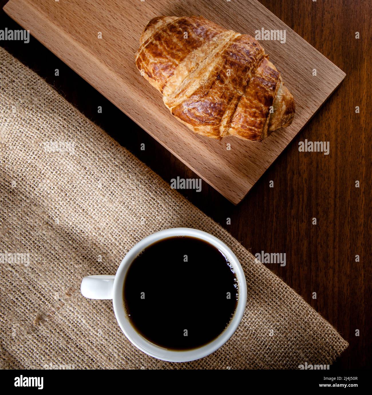 Weiße Tasse mit Filterkaffee und Croissant, Draufsicht Stockfoto