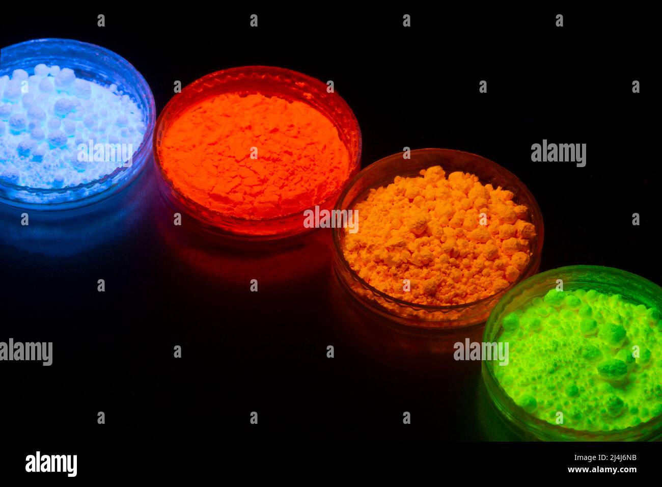 Fluoreszierendes organisches Materialpulver in roter, gelber, grüner Farbe für die Produktion von OLED-Displays im UV-Licht.Nahaufnahme. Stockfoto