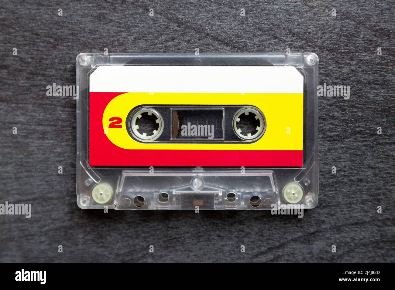 Draufsicht auf ein altes Kassettenband auf dunkelgrauem Hintergrund. Musikikone der 80s und 90s. Nahaufnahme. Stockfoto