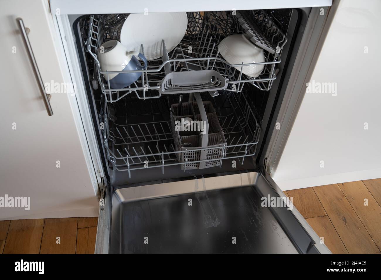 Eine offene, weiße Spülmaschine mit Geschirr. Stockfoto