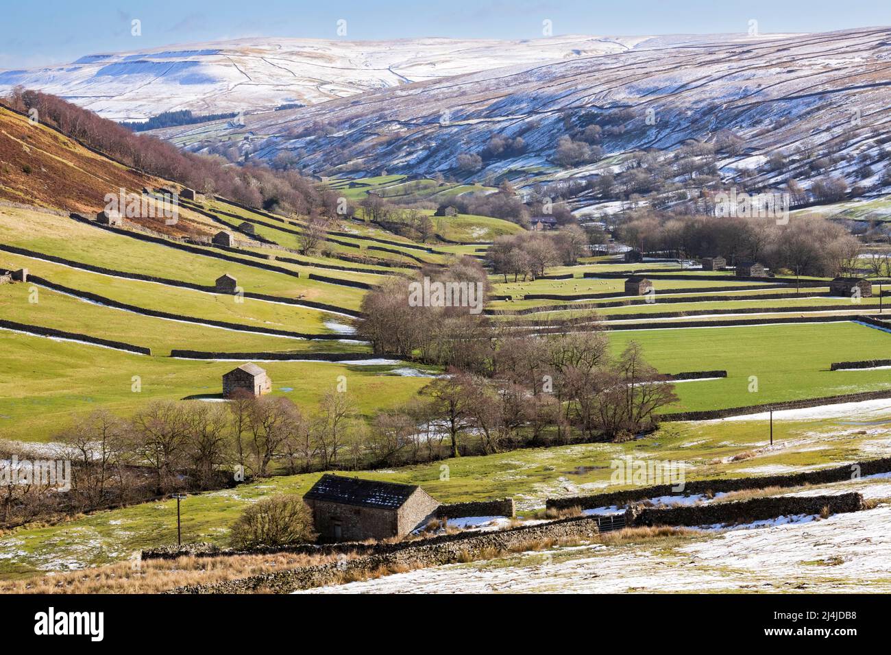Swaledale, Yorkshire Dales National Park, schneebedeckte Hügel über einem Flickenteppich aus Trockensteinmauern gesäumten Feldern und Weiden mit ikonischen Steinhäusern Stockfoto
